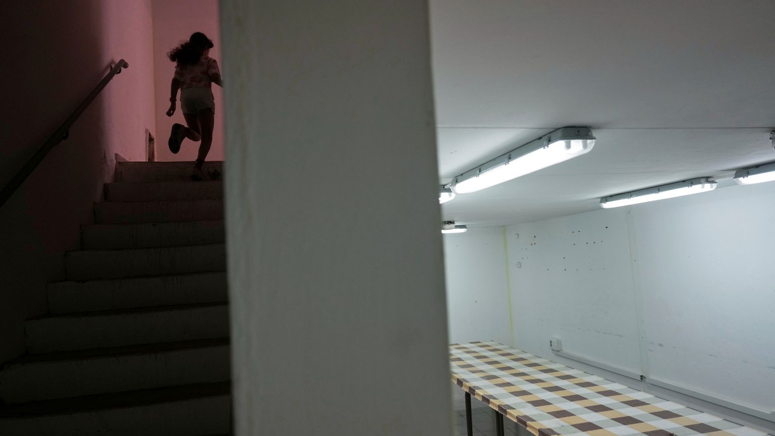 A girl runs to a bomb shelter in an apartment building in Hadera, 13 June 2025