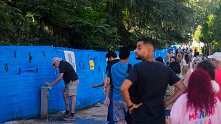 People queue to fill their water bottles up from a public drinking tap in Madrid, Spain, 19 July 2024.
