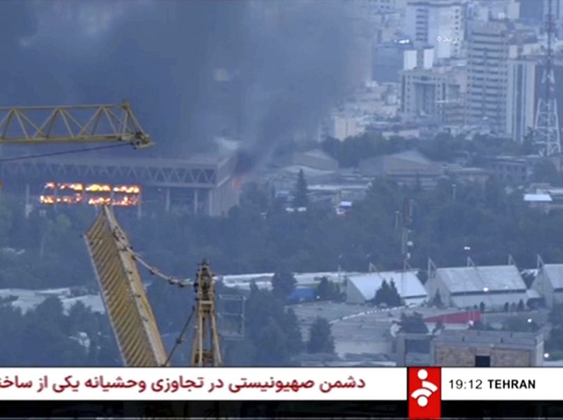 Cette capture d'écran d'une vidéo diffusée par la télévision d'État iranienne montre le bâtiment du réseau en feu après une attaque de drone israélien, le 16 juin 2025.