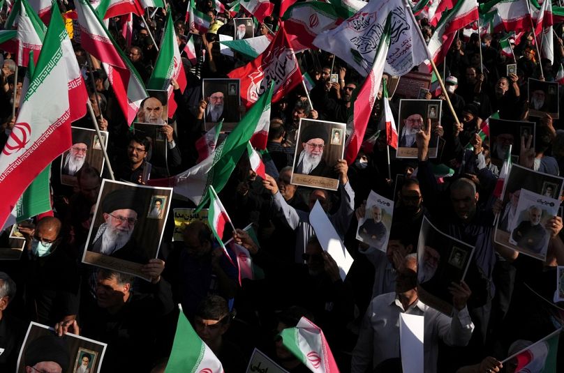 يحمل المتظاهرون الإيرانيون المؤيدون للحكومة ملصقات للمرشد الأعلى آية الله علي خامنئي وأعلام البلاد، إيران، الأحد 25 سبتمبر 2022.  