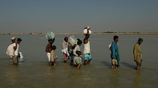Survivors wade through water in their village Khairpur Nathan Shah, Pakistan, on 2 November 2010, which is surrounded by floodwaters.