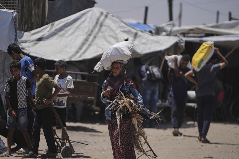 فلسطينيون يحملون أكياسًا تحتوي على مساعدات غذائية وإنسانية وزّعتها "مؤسسة غزة الإنسانية" المدعومة من الولايات المتحدة، في رفح جنوب قطاع غزة، يوم الاثنين 16 حزيران/يونيو 2025.