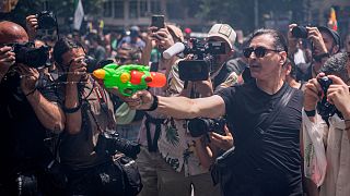 A protester holds a water gun during a protest against overtourism in Barcelona, Spain.