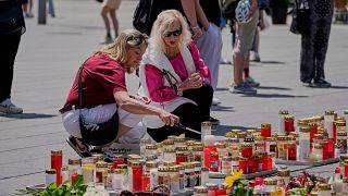 People commemorate the victims at the central square in Graz, Austria.