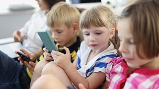 Children use mobile phones.