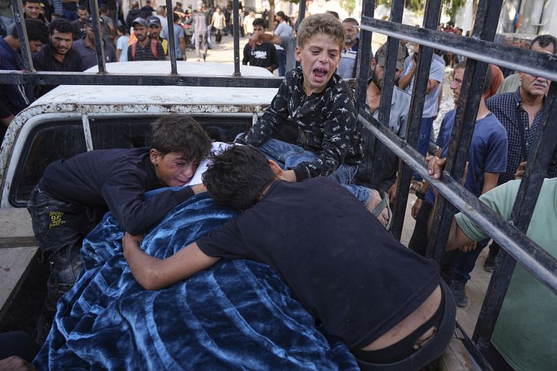 أطفال فلسطينيون ينعون جثة والدهم الذي قُتل أثناء توجهه إلى مركز توزيع المساعدات، خلال جنازته في مدينة غزة، الأربعاء 18 يونيو 2025.