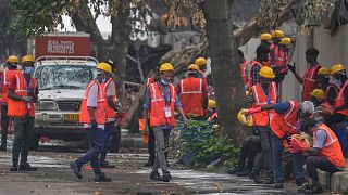 Local workers take a break near the site of the deadly Air India plane crash in Ahmedabad, India.