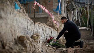 Ukrainian President Volodymyr Zelenskyy lays flowers at the site of Russia's Tuesday deadly missile attack that ruined a multistory residential building in Kyiv, June 19, 2