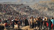 Palestinians carry sacks and boxes of food and humanitarian aid that was unloaded from a World Food Program convoy.
