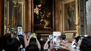 Tourists admire the Pilgrims' Madonna, by Caravaggio at the Basilica of St. Augustine in Rome.
