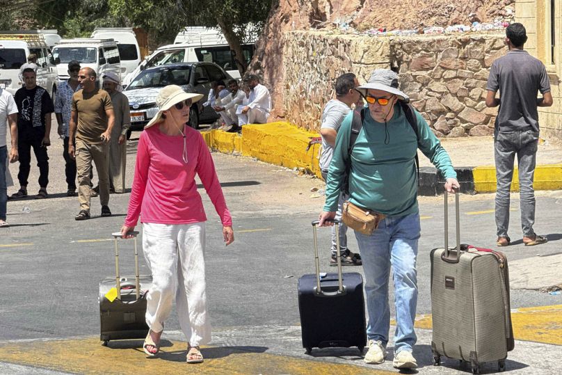 Los residentes extranjeros evacuados de Israel después de los ataques con misiles cruzan el puerto terrestre de Taba, un cruce fronterizo en la frontera oriental con Israel.
