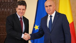 Romanian President Nicusor Dan, left, shakes hands with Ilie Bolojan, the President of the country's senate, after nominating him as the new Prime Minister 