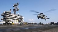 A MH-60S Sea Hawk helicopter hovering over the USS Carl Vinson aircraft carrier while operating in the Middle East April 12, 2025.