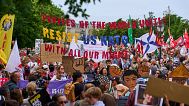 People hold banners during a demonstration ahead of the NATO summit in The Hague, Netherlands, Sunday, June 22, 2025