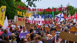 People hold banners during a demonstration ahead of the NATO summit in The Hague, Netherlands, Sunday, June 22, 2025