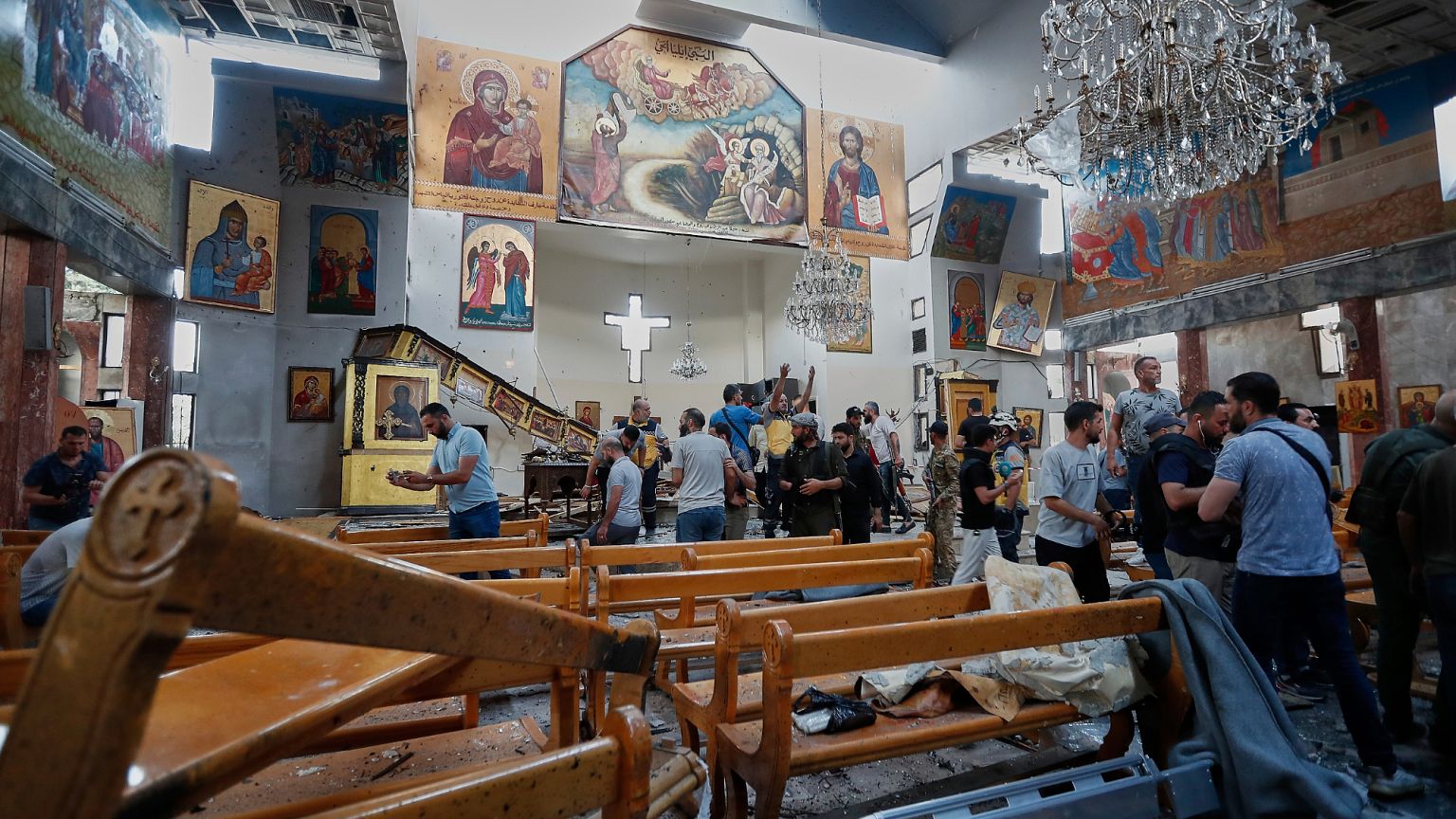 Σύριοι πολίτες και δυνάμεις ασφαλείας επιθεωρούν τις ζημιές μέσα στην εκκλησία Mar Elias, όπου ένας βομβιστής αυτοκτονίας πυροδότησε τον εαυτό του στην Dweil'a, στα περίχωρα της Δαμασκού, στη Συρία, την Κυριακή.