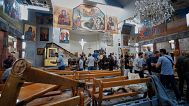 Syrian citizens and security forces inspect the damage inside Mar Elias church