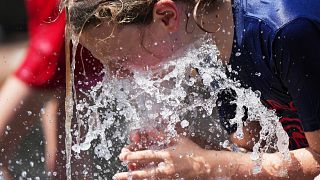 Jude Puroway cools off at a fountain during hot weather in Chicago.
