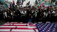 Shiite Muslims stand over a representation of U.S flag during a rally to condemn Israeli strikes on Iran, in Karachi, Pakistan, Sunday, June 22, 2025