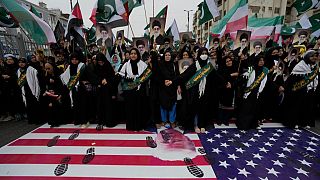 Shiite Muslims stand over a representation of U.S flag during a rally to condemn Israeli strikes on Iran, in Karachi, Pakistan, Sunday, June 22, 2025