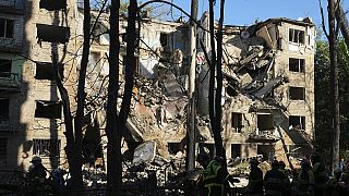 Firefighters work in a destroyed apartment building after a Russian attack in Kyiv, Ukraine, early Monday, June 23, 2025.