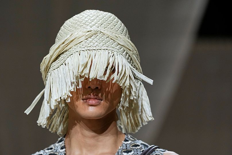 An Armani model wears a straw hats low over the eyes,