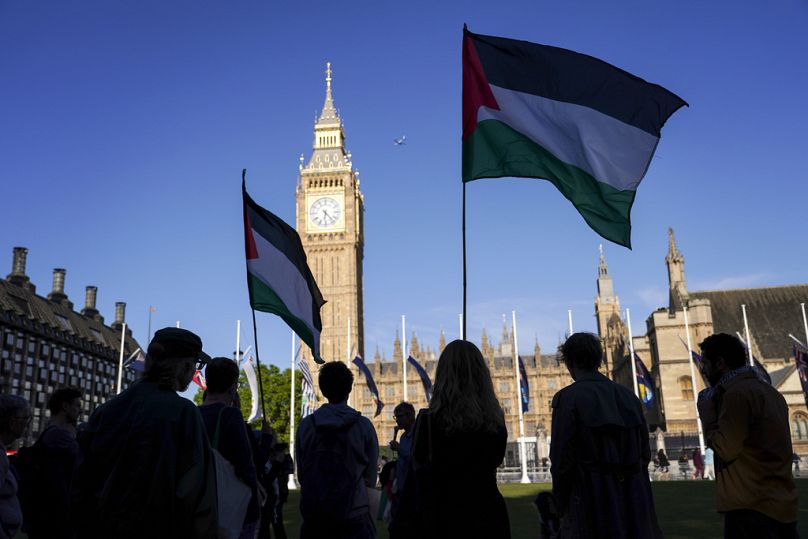 متظاهرون يرفعون الأعلام أمام البرلمان خلال احتجاج دعمًا للشعب الفلسطيني في غزة، في لندن، الأربعاء 21 أيار/ مايو 2025. 