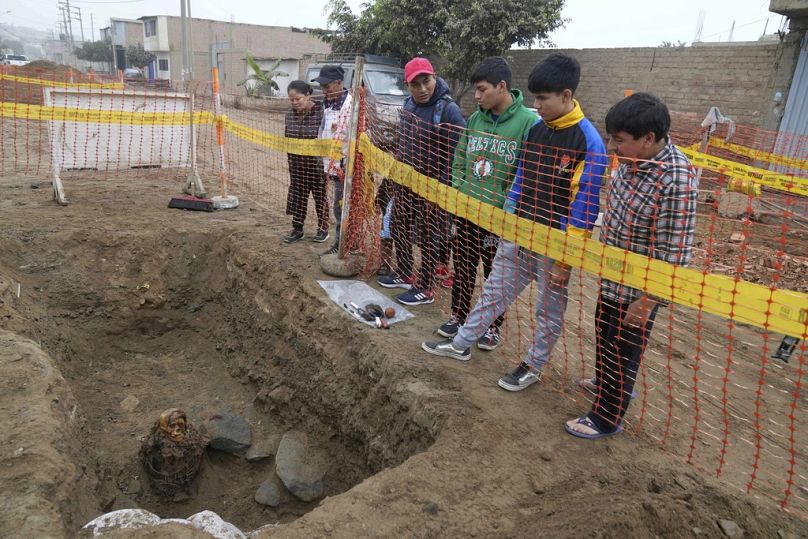 Einheimische betrachten eine alte Mumie. Es handelt sich laut den Archäologen um eine Frau aus der vorinkaischen Chancay-Kultur.