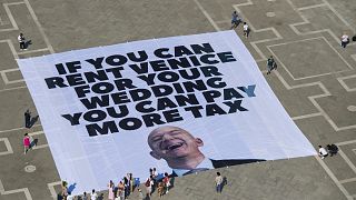 This photo released by Greenpeace shows a large banner against Amazon founder Jeff Bezos' planned wedding, in St. Mark Square, in Venice