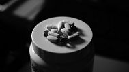 Pills sit atop a bottle.