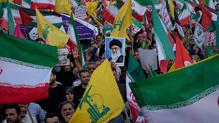 تصویری از علی خامنه‌ای، رهبر ایران در میان پرچم‌های ایران و حزب الله در راهپیمانی عید غدیر یک روز پس از جمله اسرائیل