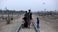 A homeless Iraqi family walks along railway tracks towards their hut outside Baghdad, 12 February, 2018