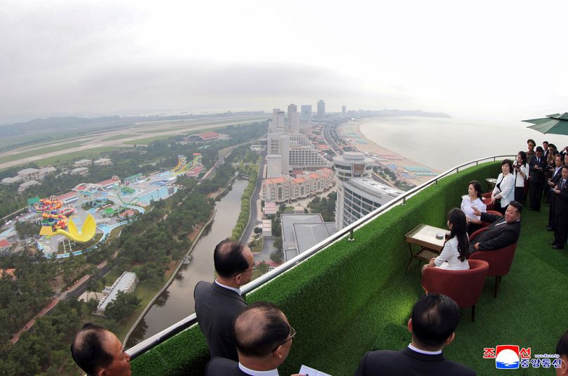 Kim Jong Un com a mulher Ri Sol Ju, atrás, e a filha, passeia pela zona turística costeira de Wonsan-Kalma, na Coreia do Norte, terça-feira, 24 de junho de 2024