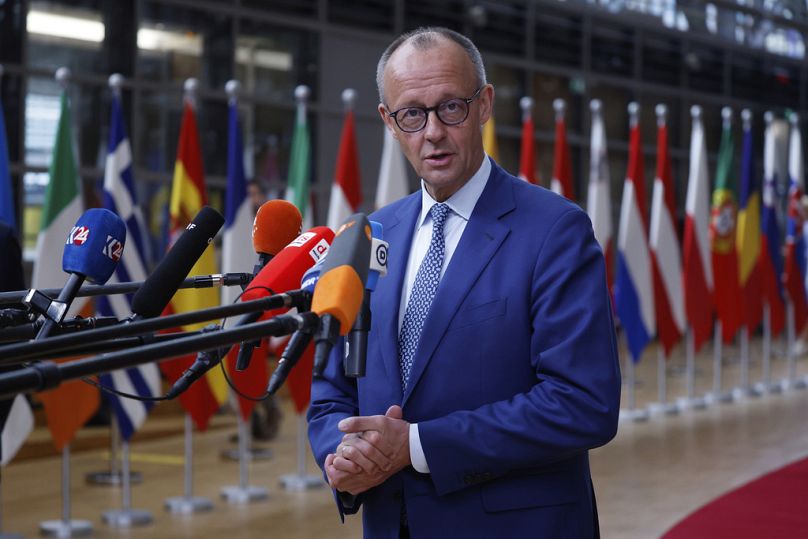 Chanceler alemão Friedrich Merz fala com os meios de comunicação social à chegada a uma cimeira da UE no edifício do Conselho Europeu em Bruxelas, quinta-feira, 26 de junho 