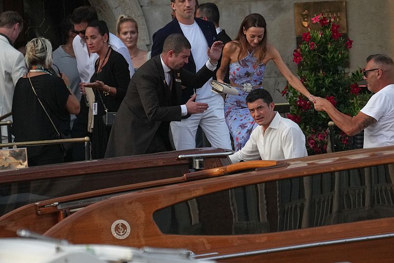 Orlando Bloom, center, leaves a hotel for the pre wedding reception of Amazon founder Jeff Bezos and Lauren Sanchez, in Venice, Italy, Thursday, June 26, 2025. 