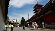 FILE - People walk in the compound of Sonsoji Temple in Tokyo's Asakusa district with the backdrop of Tokyo's new landmark Tokyo Sky Tree communication tower.