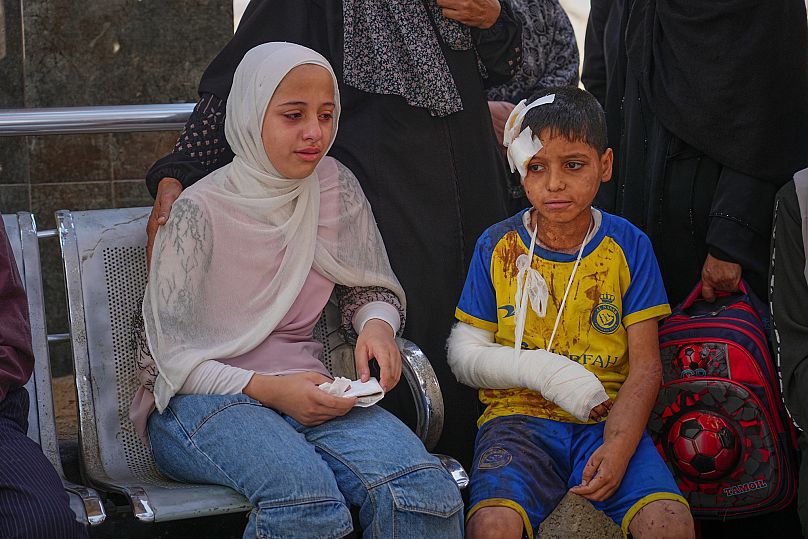 Hamam Al-Farani est assis à côté de sa sœur avant l'enterrement de leur père, Alaa, tué dans une frappe israélienne, à l'hôpital Shifa de la ville de Gaza, mardi 24 juin 2025