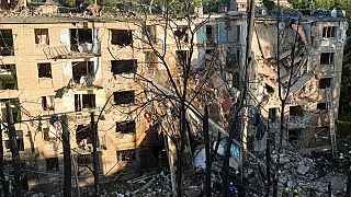 Firefighters work in a destroyed apartment building after a Russian attack in Kyiv, Ukraine, early Monday, June 23, 2025. 