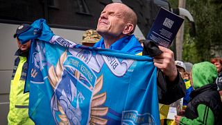 A freed Ukrainian soldier holds up his unit's flag after a POWs exchange with Russia