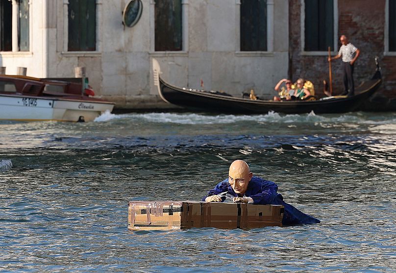 A mannequin resembling Jeff Bezos floats in a canal