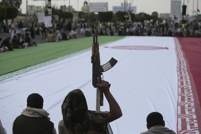 مناصرون للحوثيين يلتفون حول علم إيراني ضخم خلال تظاهرة أسبوعية مناهضة لأمريكا وإسرائيل في صنعاء، الجمعة 20 حزيران/ يونيو 2025.