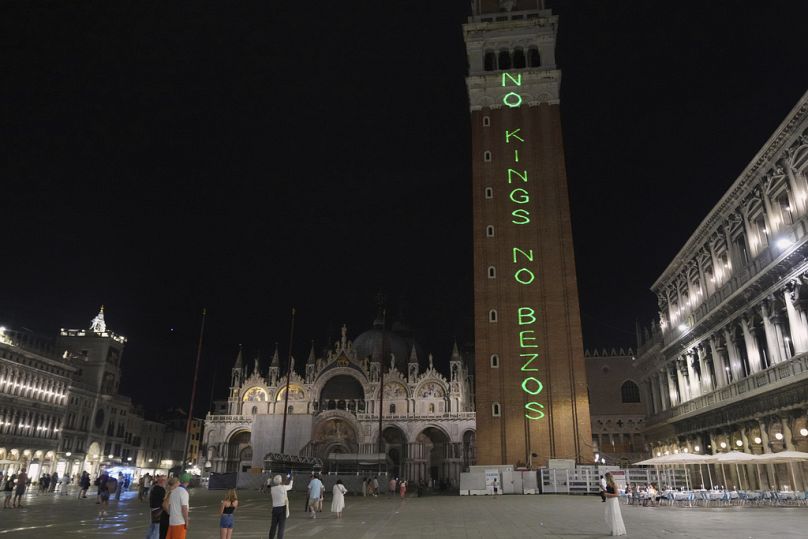 Des manifestants arborent une pancarte « No Kings No Bezos » sur la place Saint-Marc, à Venise, en Italie, le jeudi 26 juin 2025.