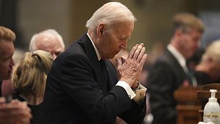 Former US President Joe Biden kneels in prayer during funeral services for Mark and Melissa Hortman at the Basilica of St. Mary in Minneapolis, Minn., on Saturday, June 28, 20