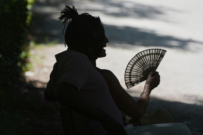 Un homme se repose dans le parc du Retiro à Madrid, Espagne, samedi 28 juin 2025. (AP Photo/Paul White)