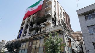 پرچم ایران بر روی ساختمان آسیب‌دیده در حملات اسرائيل به تهران