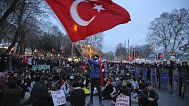  طلاب جامعيون يجلسون بجانب ضباط شرطة مكافحة الشغب خلال احتجاج بعد اعتقال رئيس بلدية إسطنبول أكرم إمام أوغلو وإرساله إلى السجن، في إسطنبول، تركيا، الاثنين، 24 مارس/آذار 2025