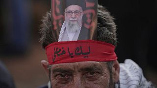 یک طرفدار حزب‌الله با تصویری از علی خامنه‌ای در مقابل سفارت ایران در بیروت در تاریخ ۲۵ ژوئن 
