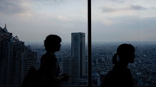 Visitors look at the city from the Tokyo Metropolitan Government observatory in Tokyo, Friday, June 27, 2025.