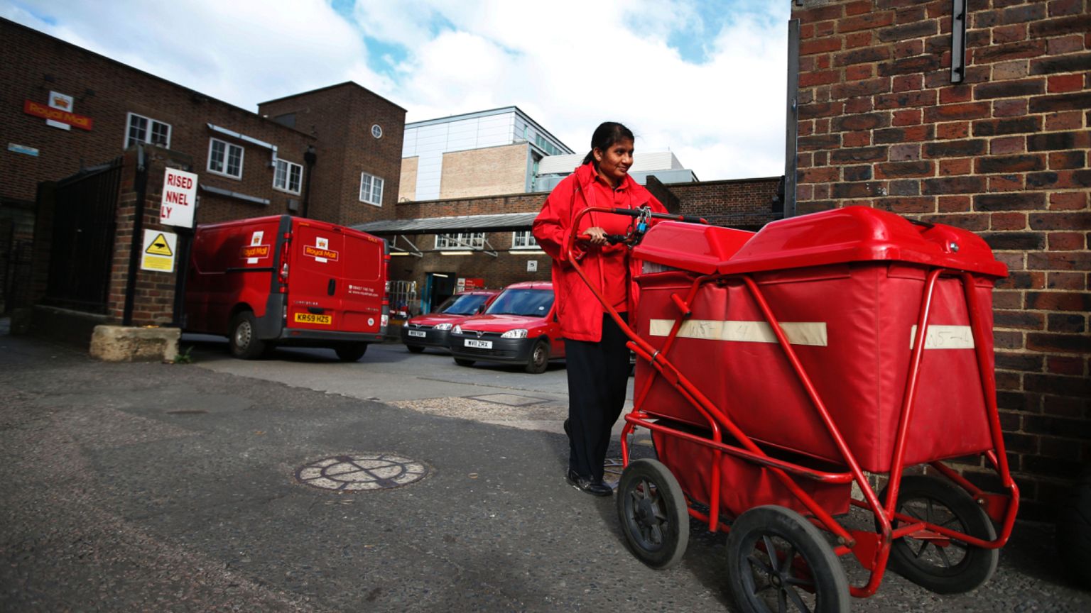 A Royal Mail post officer walks out of a Post Office depot in London, Thursday, Oct. 10, 2013.