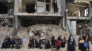 مرضى يجلسون وسط دمار مجمّع مستشفى الشفاء في غزة، في 1 تموز/يوليو 2025.
